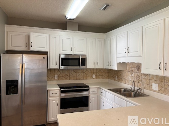 A kitchen with white cabinets and stainless steel appliances.