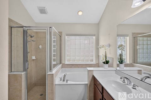 A bathroom with a tub, sink, and shower.