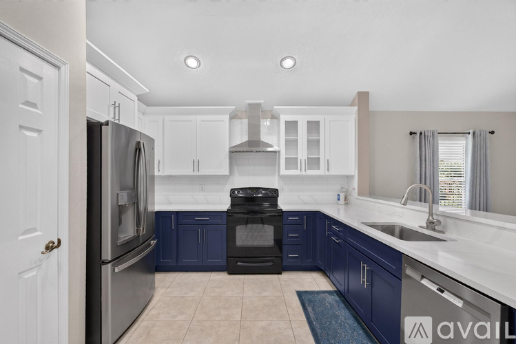 A kitchen with white cabinets and a black oven.
