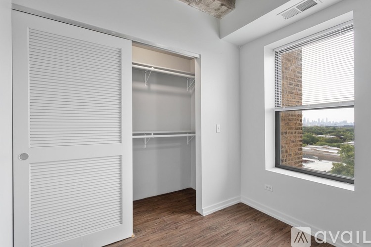 A room with a white door and a window with a view of a cityscape.