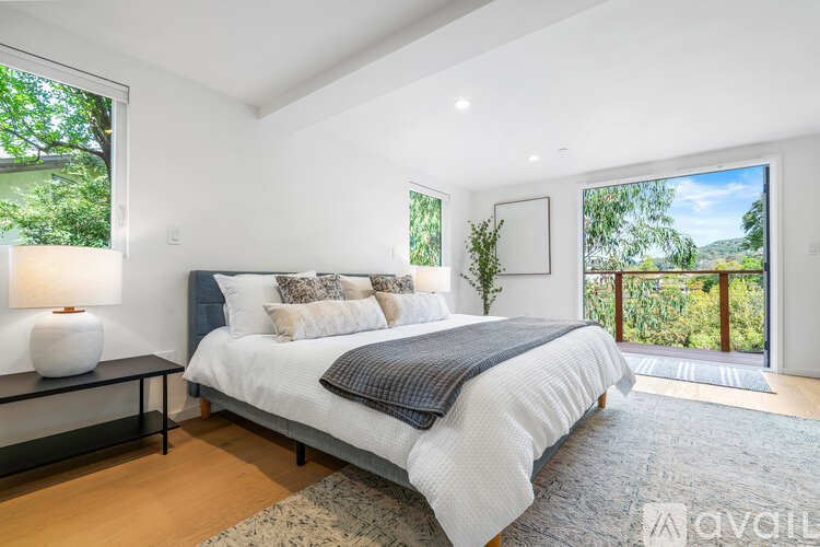 A bedroom with a large bed and a view of the outdoors through the window.