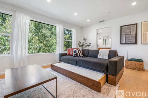 A modern living room with a grey sofa and a wooden coffee table.
