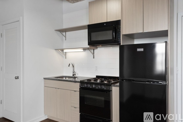 A kitchen with black appliances and wooden cabinets.