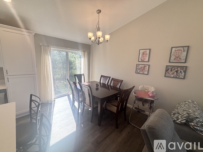 A dining room with a table set for four and a couch.