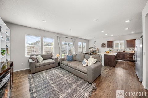 A living room with a grey sofa and a grey rug.