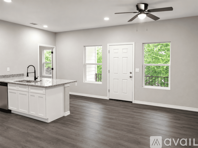 A spacious kitchen with a white island and a ceiling fan.