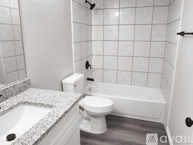 A white toilet sits next to a bathtub in a bathroom.