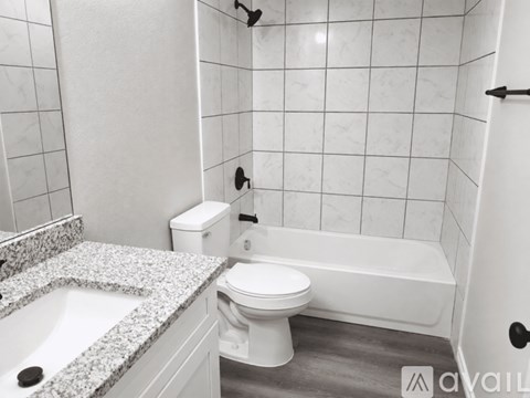 A white toilet sits next to a bathtub in a bathroom.