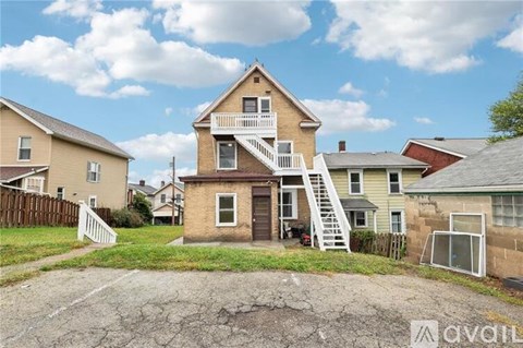 A house with a balcony and a staircase leading to the second floor is for sale.