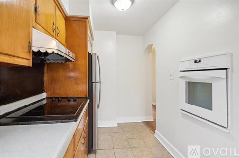 A kitchen with wooden cabinets and a white oven.
