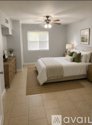 A bedroom with a bed, dresser, and ceiling fan.