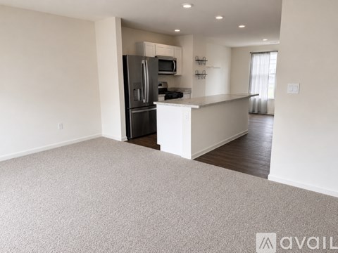 A spacious kitchen with a refrigerator, microwave, and oven.
