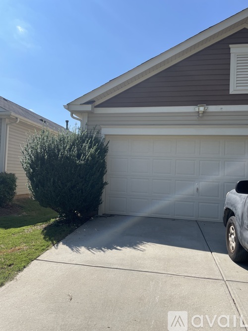 A car is parked in front of a garage.