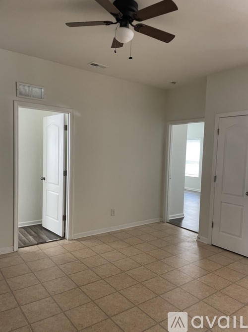 A room with a ceiling fan and tile flooring.