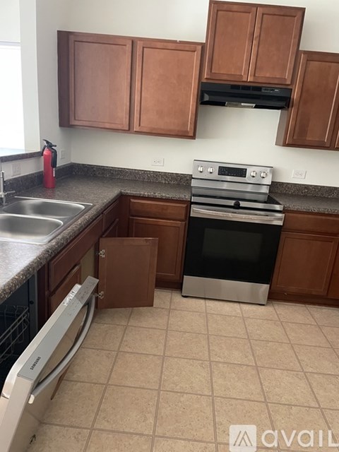 A kitchen with brown cabinets and a stainless steel dishwasher.