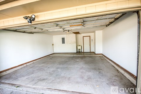 A spacious garage with a concrete floor and white walls.