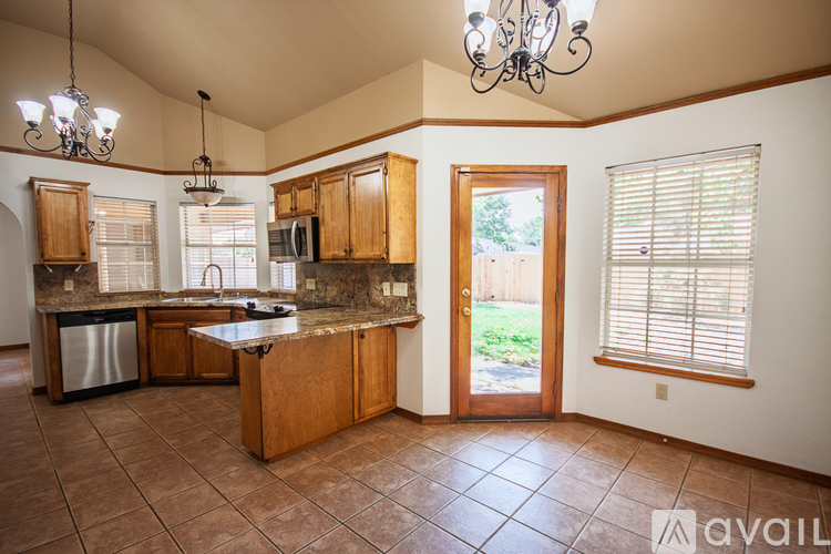A kitchen with brown cabinets and a tiled floor.