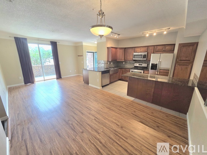 A well-lit kitchen with wooden floors and a large island.