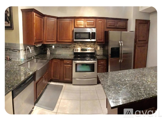A kitchen with granite countertops and stainless steel appliances.