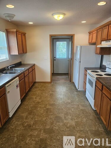 A kitchen with brown cabinets and a tiled floor.