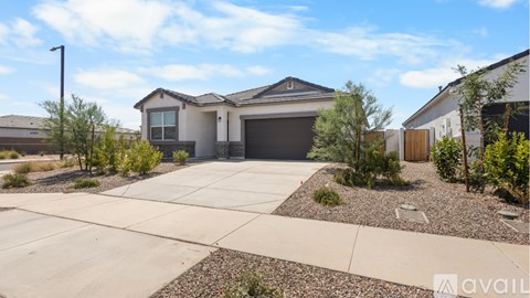 A house with a garage and a driveway in front of it.
