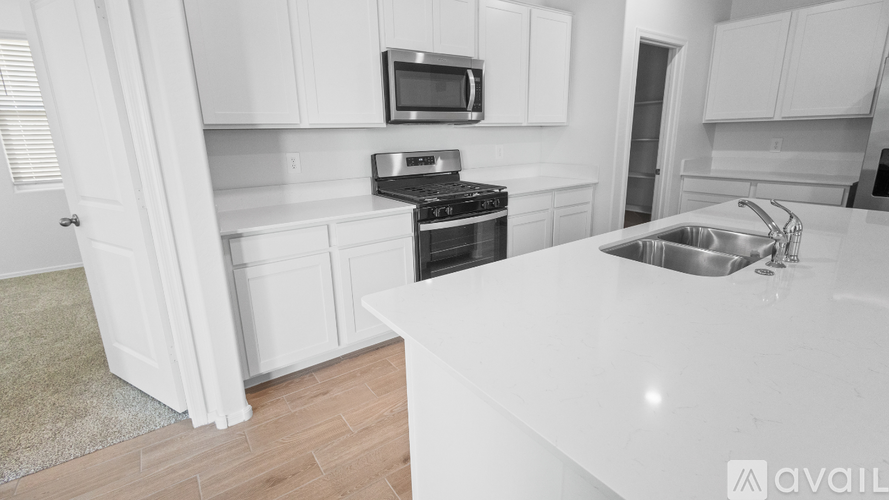 A kitchen with white cabinets and a white countertop.