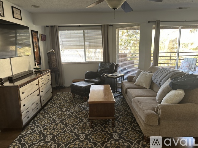 A living room with a couch, chair, and ottoman.