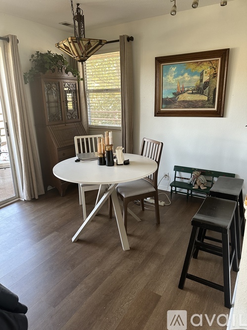 A dining room with a white table and chairs.