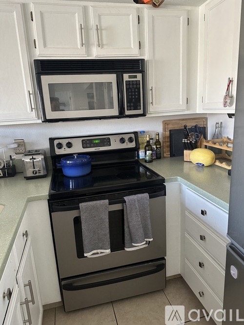 A kitchen with a black stove top oven and a white microwave above it.