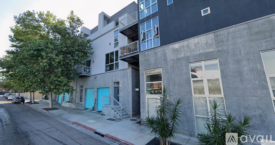 A street view of a building with a blue door and windows.