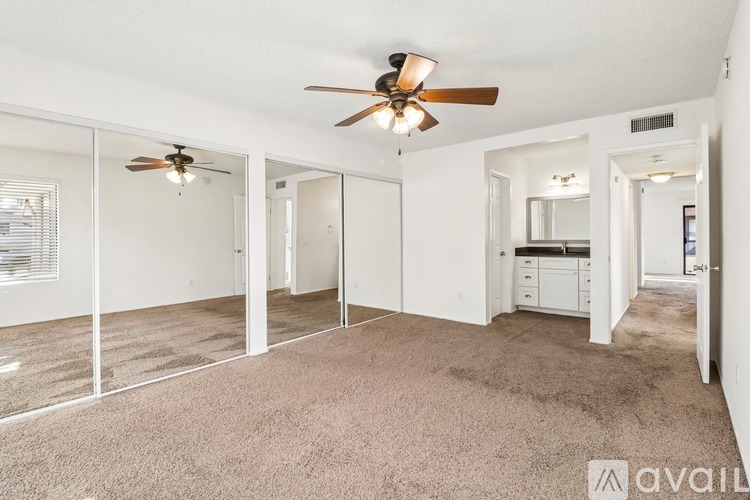 A spacious room with a ceiling fan and sliding glass doors.