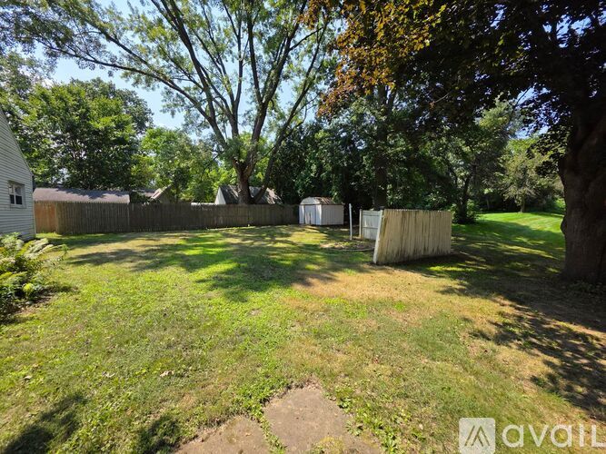 A backyard with a wooden fence and trees.