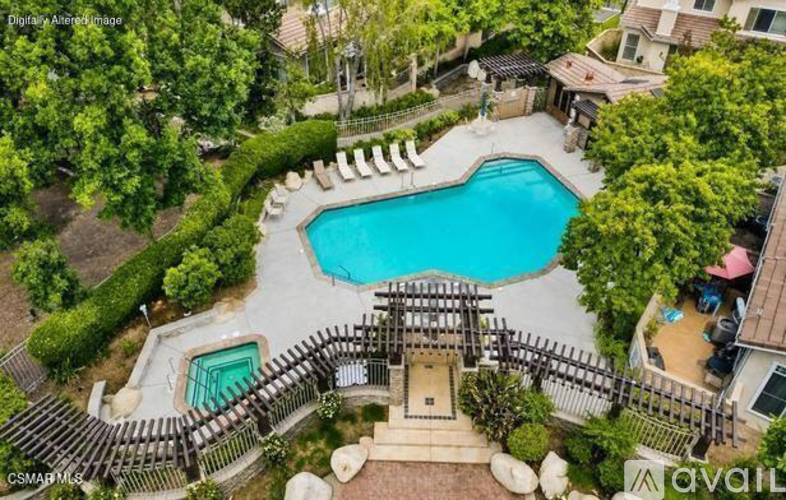 A beautifully landscaped backyard with a pool and a deck.