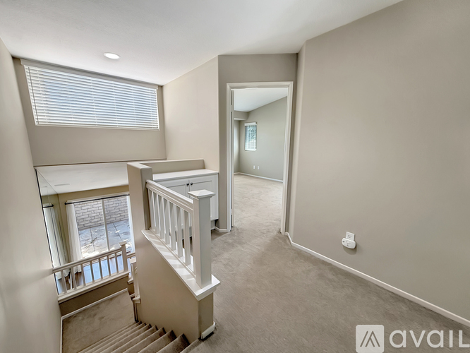 A spacious room with a staircase leading to the upper floor.