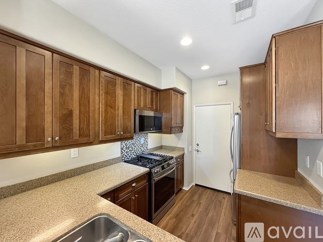 A kitchen with wooden cabinets and a granite countertop.