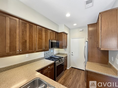 A kitchen with wooden cabinets and a granite countertop.