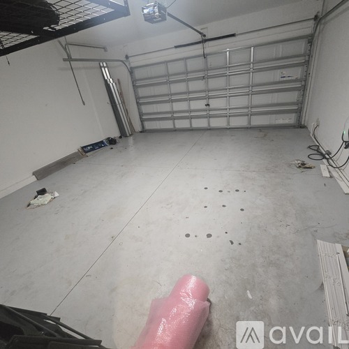 A garage with a white floor and a silver garage door opener.