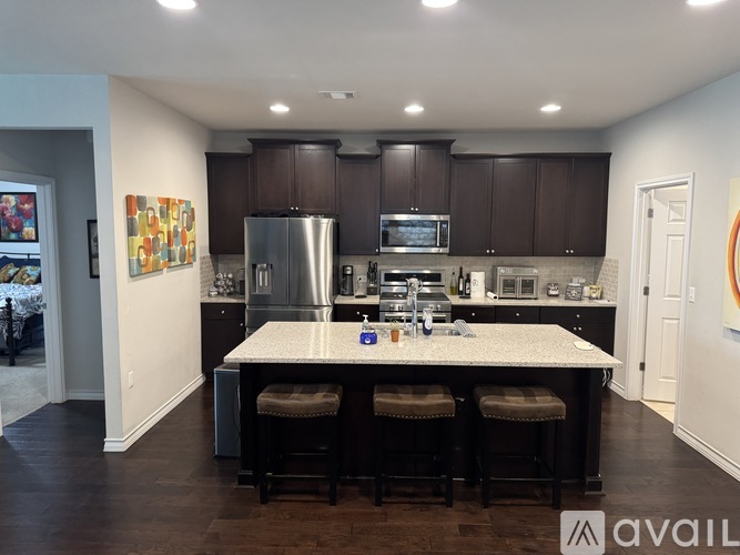 A kitchen with dark brown cabinets and a white island.