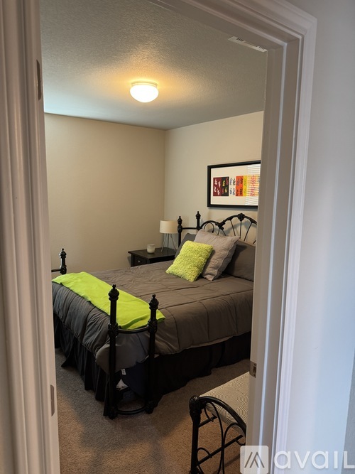A bedroom with a bed and a painting on the wall.