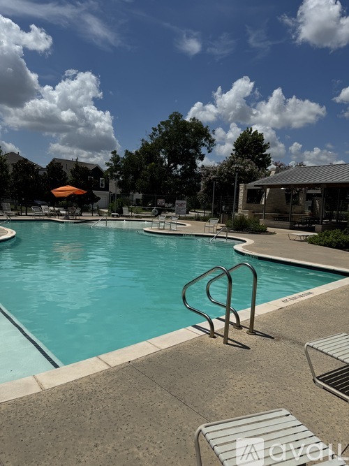A pool with a slide and a sun umbrella.