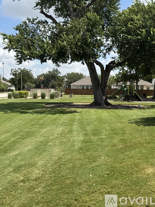 A large tree in the middle of a grassy area.