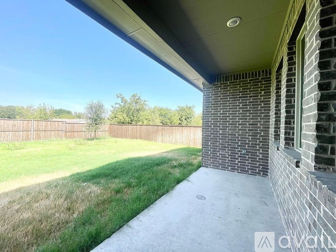 A house with a fence and a grassy area in the background.