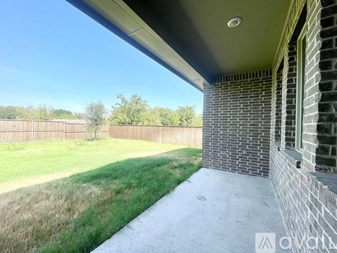 A house with a fence and a grassy area in the background.