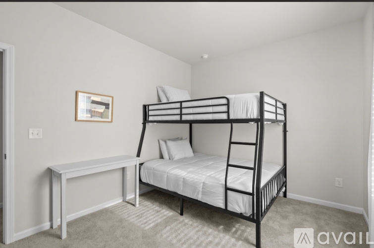 A bedroom with a bunk bed and a small table.