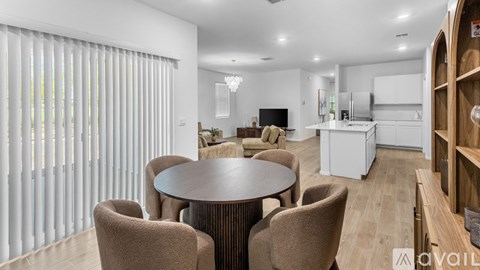 A modern dining room with a round table and chairs.