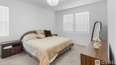 A bedroom with a large bed and a wooden nightstand.
