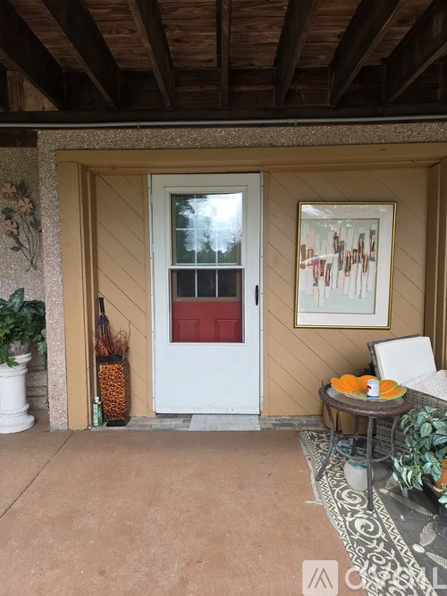 A white door with a red window is on the left and a framed picture is on the right.
