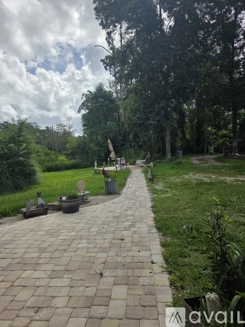 A brick pathway leads through a grassy area with a sign that reads "AVAIL".