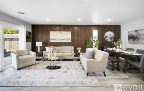 A modern living room with a white sofa set and a dining table.
