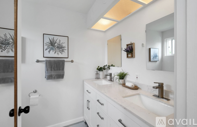 A bathroom with a white sink and a mirror.